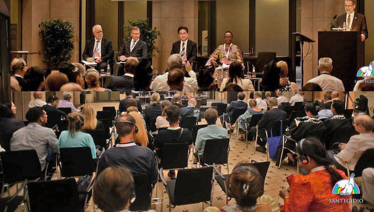 Chair (on podium), four panelists and a section of the audience of the Forum on "A World Free of Nuclear Weapons is Possible" on 11 September 2023 in Berlin held as part of the International Meeting "The Audacity of Peace" hosted by the lay Catholic Association Community of Sant’Egidio. The Forum was co-organized by Soka Gakkai International. Credit: Sant'Egidio.