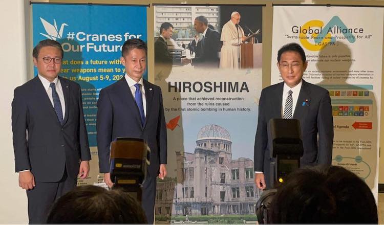 Photo: Meeting with Japanese Prime Minister Fumio Kishida (right) in front of the Hiroshima (banner) exhibition at United Nations on August 1, 2022. Source: Mariko Komatsu