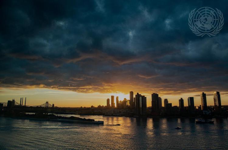 照片。在大会第七十六届会议（2021年）一般性辩论的第一天黎明，太阳从长岛市的摩天大楼后面升起。联合国图片/Mark Garten